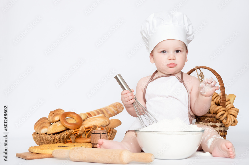 Little boy in a cook cap and with bread funny little chef Little boy in a cook cap and with bread funny little chef