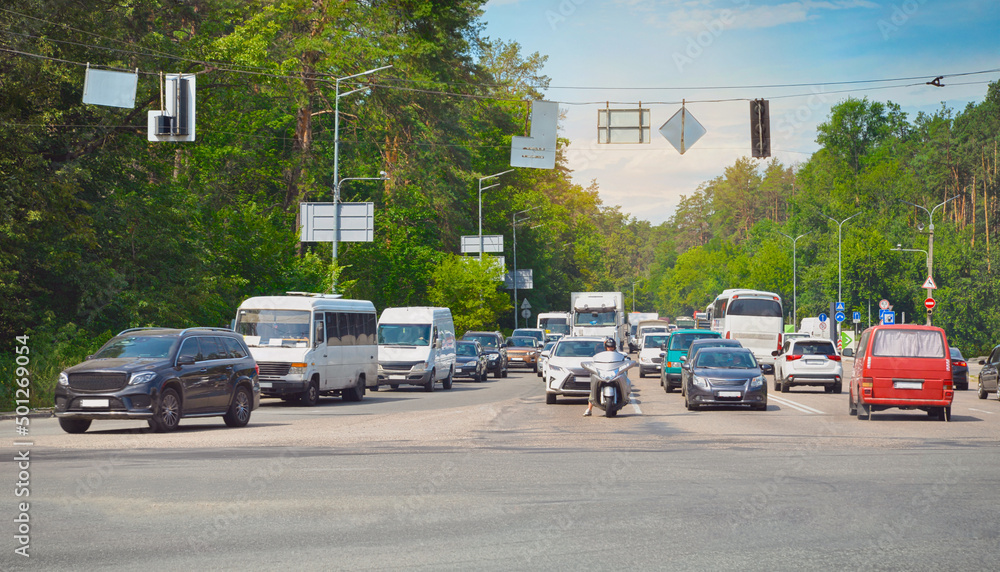 Road traffic. Busy crossroads in summer time. Suburban traffic in Ukraine. Kyiv suburb.
