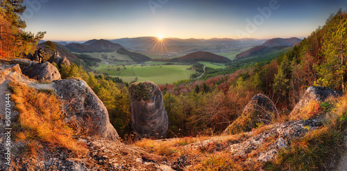 Scenic landscape in Sulov, Slovakia, on beautiful autumn sunrise with colorful leaves on trees in forest and bizarre pointy rocks on mountains valleys.