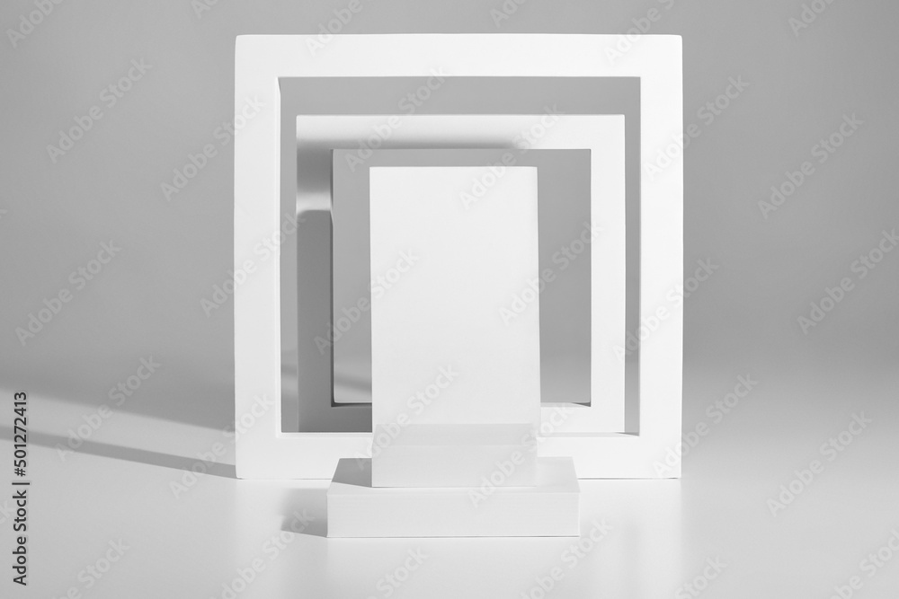 Minimalist podium design of square platforms and frames on gray background Minimalist podium design of square platforms and frames on gray background