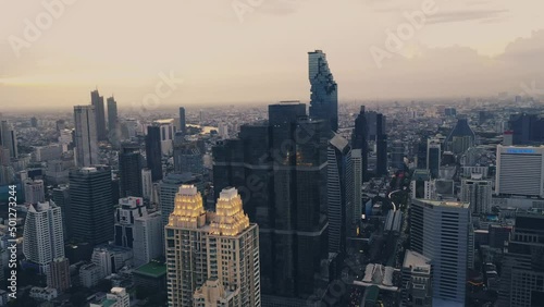 Aerial 4K video flying over the conterporary Bangkok district with scyscrapers