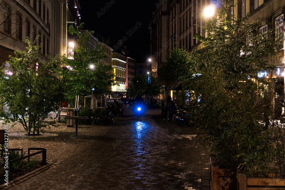 Naklejka premium Biker driving at night through streets