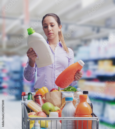 Canvas Print Woman comparing products at the supermarket