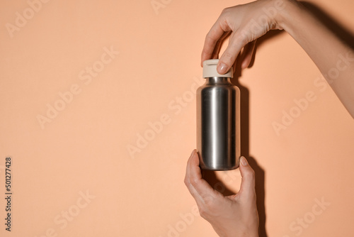 Reusable iron water bottle in a woman's hand. Steel water bottle to limit the use of plastic bottles