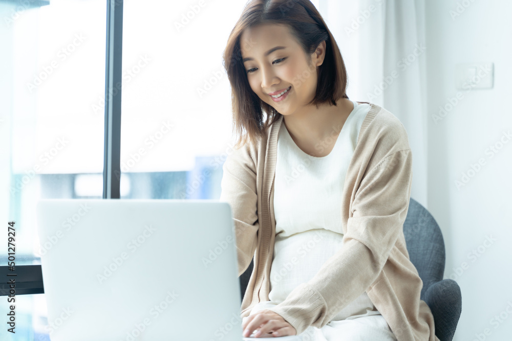 Portrait of young Asian pregnant girl using laptop at home. Portrait of young Asian pregnant girl using laptop at home.