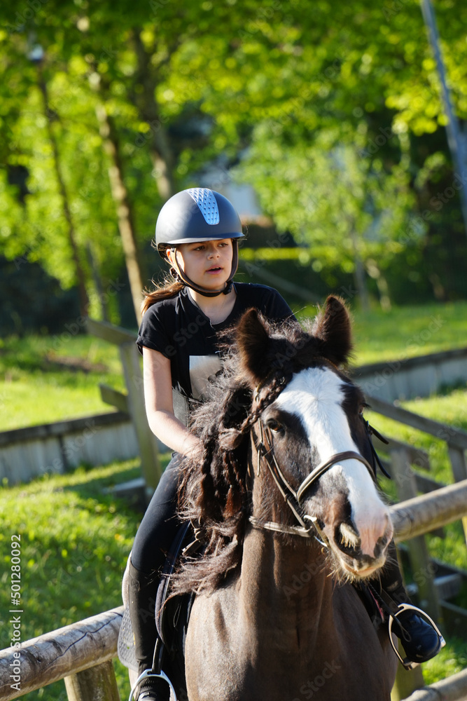 young girl on horseback in an equestrian center young girl on horseback in an equestrian center