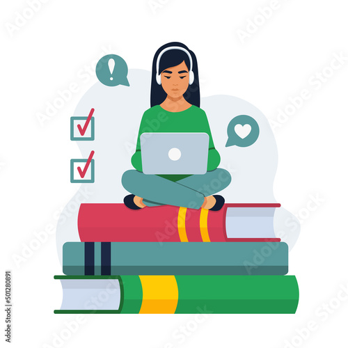 A girl on books with a laptop on her lap