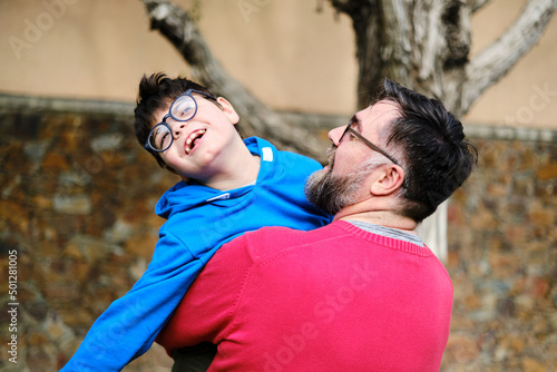 Fotografi Loving father holding and playing with his disabled son while enjoying time together outdoors