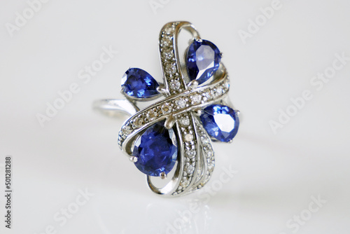 beautiful rich ring with blue tanzanite stones and  many white diamonds on white background photo
