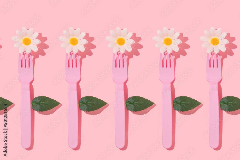 Spring creative pattern with pastel pink fork, white flower heads and leaves on pastel pink background. 80s or 90s aesthetic fashion food restaurant concept. Minimal romantic summer idea.