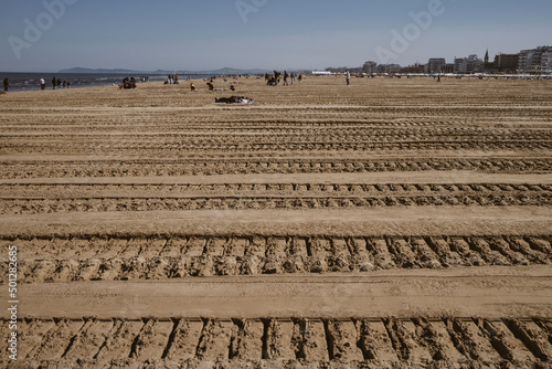 Tracce di cingolato sulla sabbia della spiaggia del mare adriatico. Preparazione degli stabilimenti balneari per l'estate e pulizia della sabbia photo