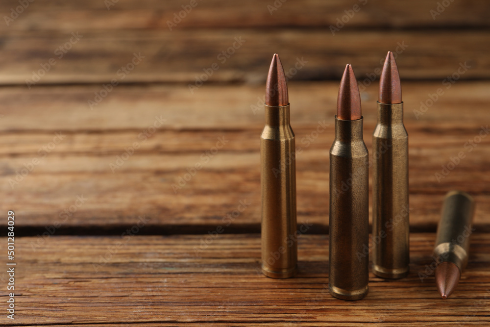 Many bullets on wooden table. Space for text