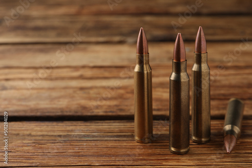 Many bullets on wooden table. Space for text