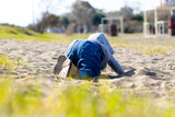 Sweet baby boy in hoodie and jeans playing in the sand. Activity with toddler.