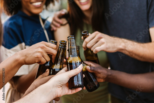 Photography Multiracial young friends cheering with beer at summer music party