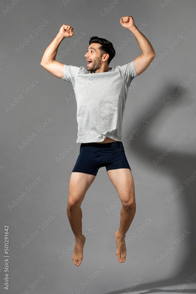 Delighted beard caucasian man in casual wear jumping on gray isolated background in studio Delighted beard caucasian man in casual wear jumping on gray isolated background in studio