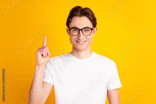 Photo of young handsome man point finger idea plan clever solution decision isolated over yellow color background