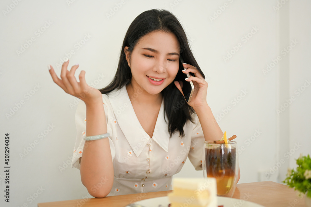 Attractive Asian young female talking on the phone white her friend Attractive Asian young female talking on the phone white her friend