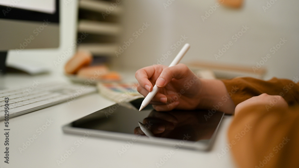 Female or graphic designer using stylus pen, drawing on tablet screen. Female or graphic designer using stylus pen, drawing on tablet screen.