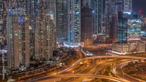 Aerial view on Dubai Marina with big highway intersection night timelapse and skyscrapers around, UAE