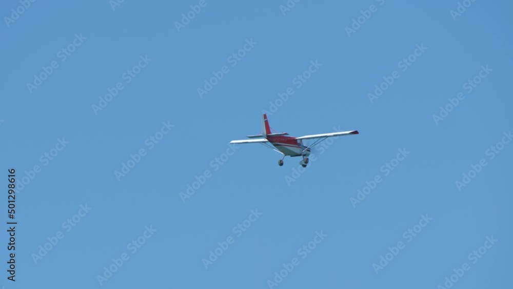 Airplane flies in blue sky. Fixed wing aircraft with rotating airscrew in front moving in heavens. Small propeller-driven plane. Bottom view. Safe transportation, logistics. Aviation, insurance Airplane flies in blue sky. Fixed wing aircraft with rotating airscrew in front moving in heavens. Small propeller-driven plane. Bottom view. Safe transportation, logistics. Aviation, insurance