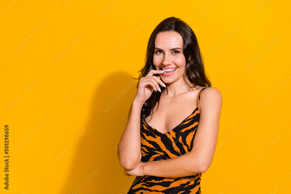 Photo of young lovely woman finger touch teeth romantic dreamy isolated over yellow color background Photo of young lovely woman finger touch teeth romantic dreamy isolated over yellow color background