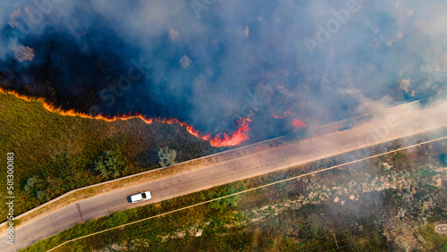 Beginning of the fire in a grassy field near the edge of the highway