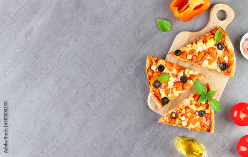 Pieces of vegetable pizza on a gray background, copy space