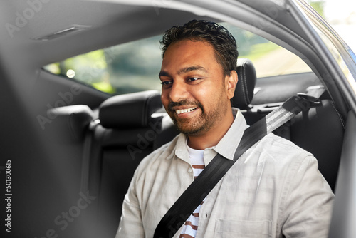 transportation, vehicle and people concept - smiling indian male passenger in taxi car
