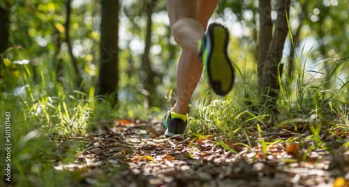Photography Woman runner running on forest trail.