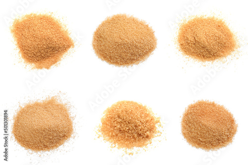 Piles of brown sugar on white background, top view