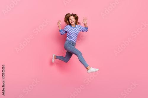 Fototapeta Naklejka Na Ścianę i Meble -  Full body photo of blond small girl run wear sweater jeans sneakers isolated on pink background
