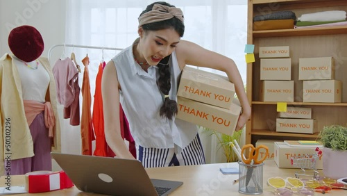 Entrepreneur Asian young business woman owner of SME online checking product on stock and save to laptop working at home.