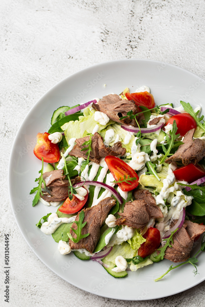 Beef tongue salad with fresh vegetables. Serving food in a restaurant. Photo for the menu