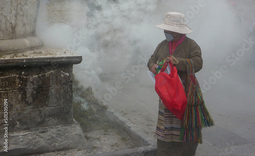 Woman at a smoke offering (Sang Sol) in Tibet

