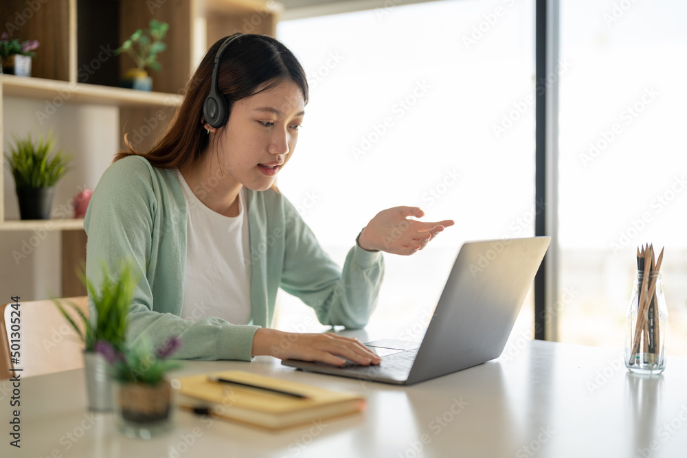 Online learning, portrait of happy asian female freelancer or smiling woman student using a laptop for a video call with a teacher, distance education concept Online learning, portrait of happy asian female freelancer or smiling woman student using a laptop for a video call with a teacher, distance education concept