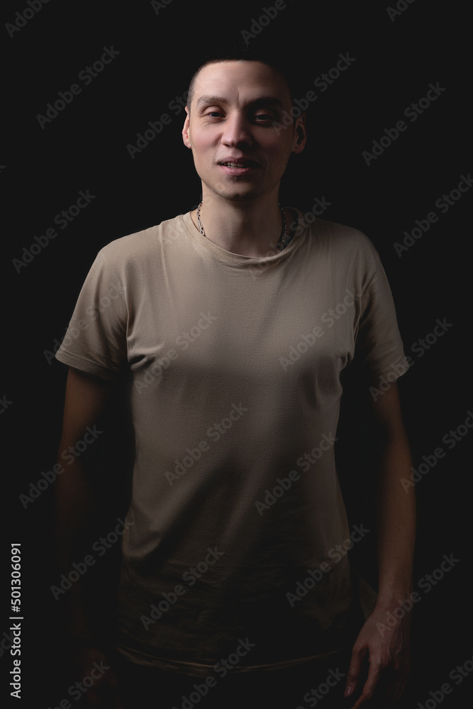 Handsome guy posing in studio on isolated black background. Studio portrait with one light source. Handsome guy posing in studio on isolated black background. Studio portrait with one light source.