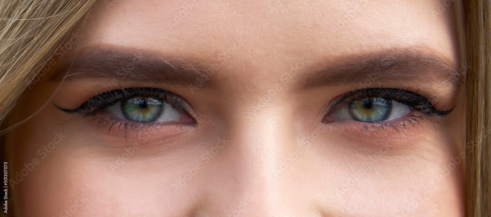 Obraz premium Close-up face of pretty girl with beautiful big blue and green eyes. Big eyelashes and eyebrows.