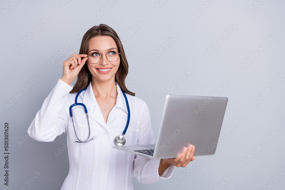 Photo of specialist doc lady hold netbook empty space easy online vaccine entry queue isolated over grey color background Photo of specialist doc lady hold netbook empty space easy online vaccine entry queue isolated over grey color background