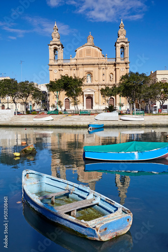 Msida Parish church reflected in St George's harbour during the morning