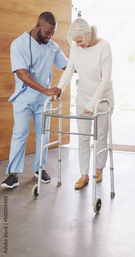 Vertical video of happy african american male physiotherapist exercising with senior patient Vertical video of happy african american male physiotherapist exercising with senior patient