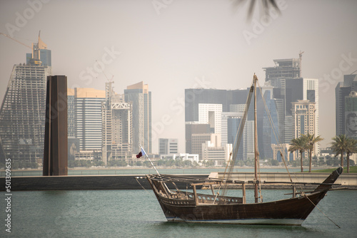 Doha,Qatar- April 24,2022 : Traditional dhow boats with the futuristic skyline of Doha in the background.