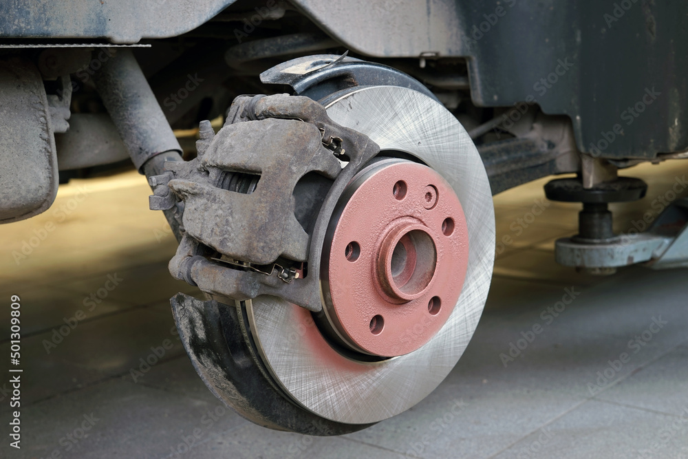 A new brake disc is installed on the car. The brake caliper is corroded. Selected focus. A new brake disc is installed on the car. The brake caliper is corroded. Selected focus.