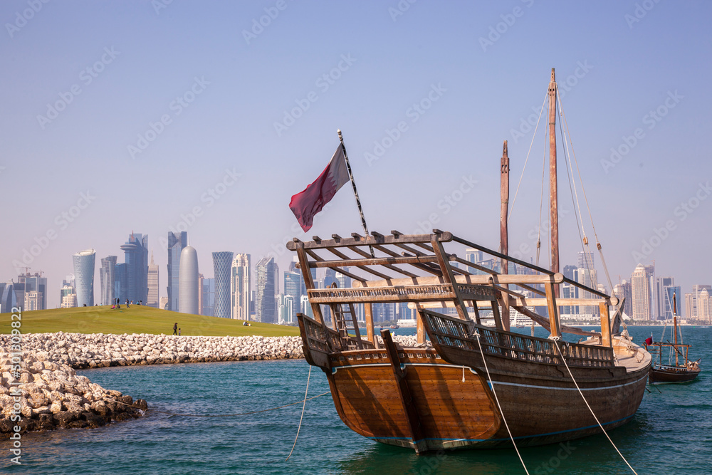 Fototapeta premium Doha,Qatar- April 24,2022 : Traditional dhow boats with the futuristic skyline of Doha in the background.