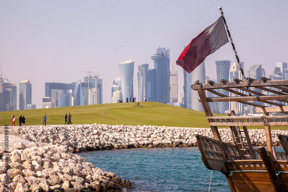 Naklejka premium Doha,Qatar- April 24,2022 : Traditional dhow boats with the futuristic skyline of Doha in the background.