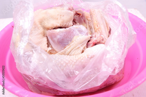closeup, pile of chicken pieces in a pink bowl. plain white isolated