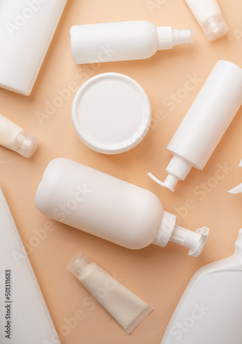 Group of white blank packaging tubes and containers for cosmetics on beige natural color background, mockup design, eco friendly