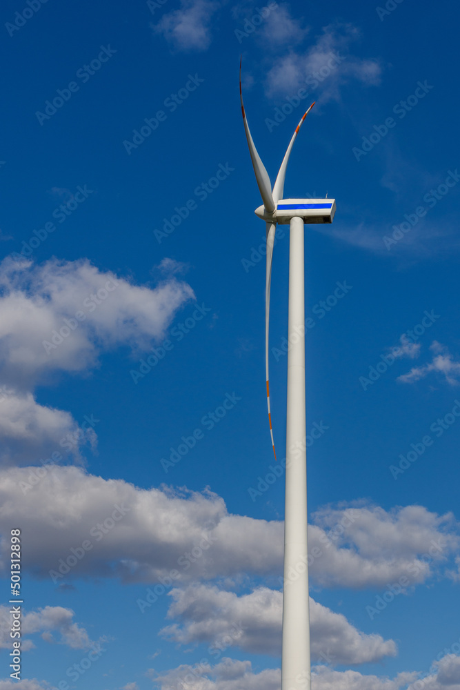 Turbina wiatrowa z profilu na tle chmur w słoneczny dzień Turbina wiatrowa z profilu na tle chmur w słoneczny dzień