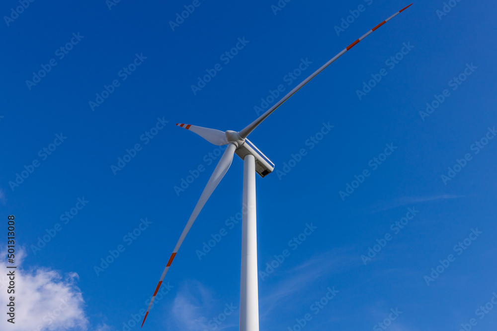 Turbina wiatrowa na tle nieba z perspektywy dolnej.
Ekologiczne rozwiązania energetyczne źródeł odnawialnych.    - obrazy, fototapety, plakaty 