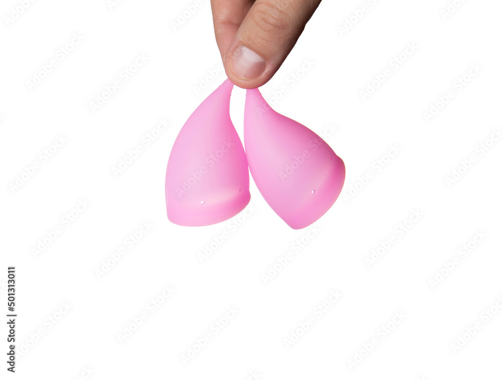 A male hand holds two female vaginal cup for collecting menstruation. White background, isolate, close-up A male hand holds two female vaginal cup for collecting menstruation. White background, isolate, close-up